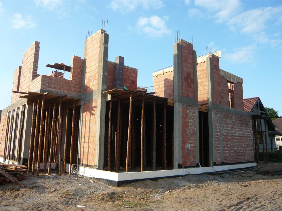 Stan surowy: żelbetowe słupy i belki oraz murowane ściany piętra w trakcie prac