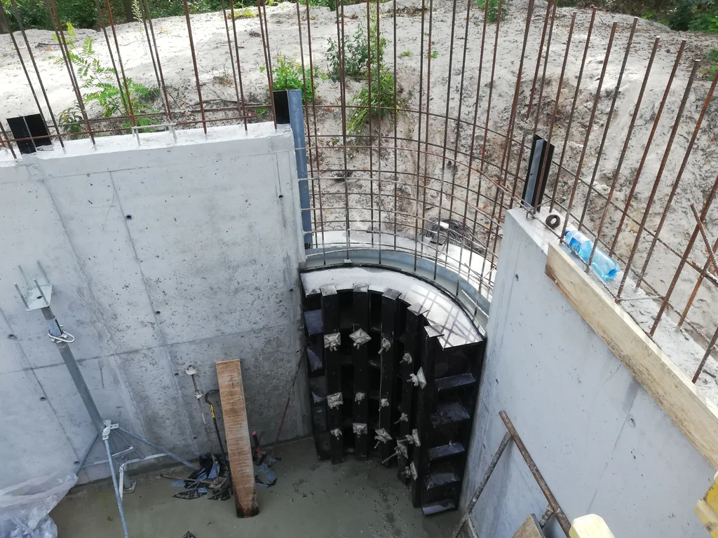 Zaokrąglona ściana żelbetowa w głębokim wykopie podczas realizacji kondygnacji podziemnej