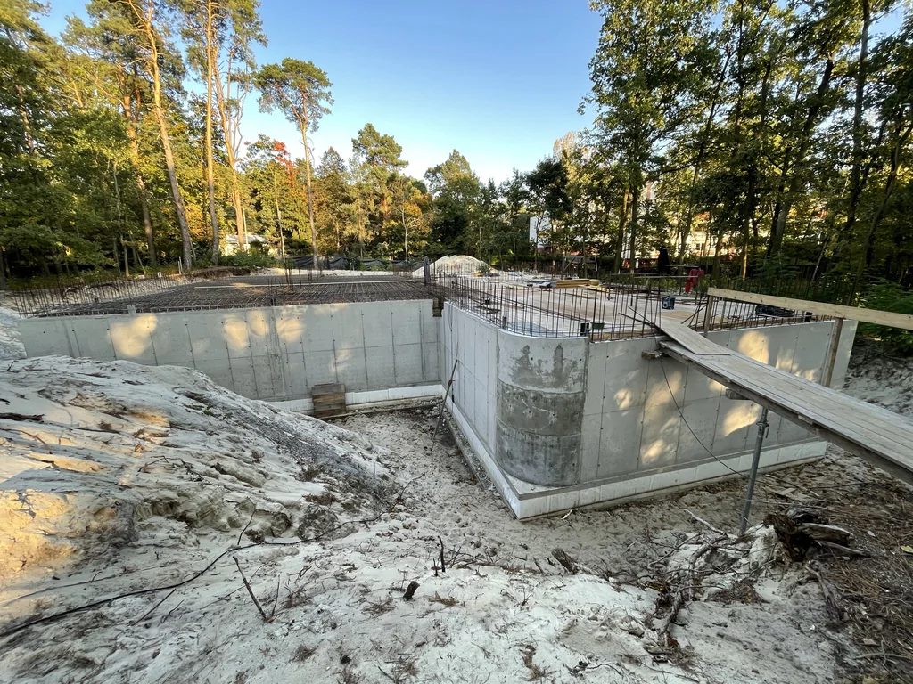 Widok wykopu z gotowymi ścianami podziemia i mostkiem roboczym do zbrojonego stropu