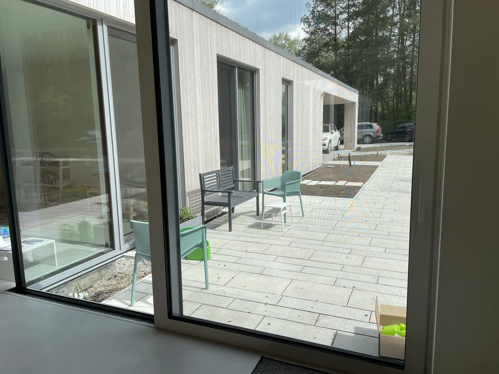 Widok z wnętrza na patio i nowoczesną elewację domu