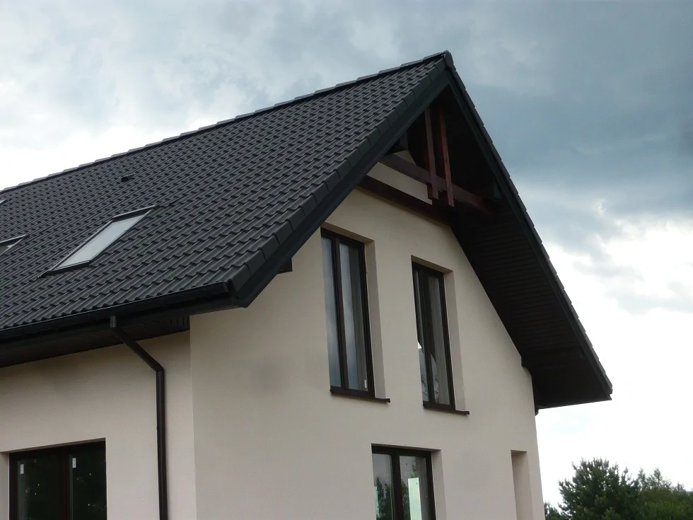 Detal dachu i elewacji: grafitowa dachówka, podbitka i rynny oraz okna na poddaszu