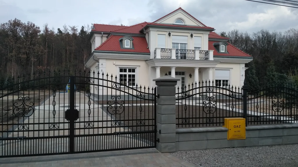 Budowa domu jednorodzinnego, styl dworkowy, dachówka z karpiówki, biała elewacja, bonie, lukarny, kominy, biała stolarka okienna, ogrodzenie 