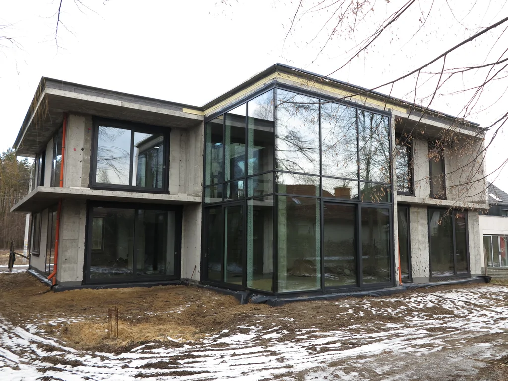 Stan surowy budynku, ściany pustak ceramiczny, dach płaski, duże przeszklenia